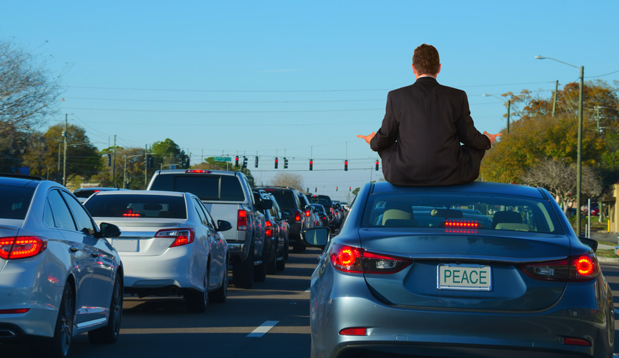 Man sitting on top of car in traffic jam